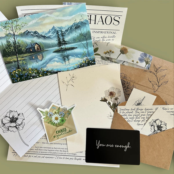 Collection of stationery items including cards, envelopes, and a motivational card on a green background